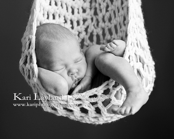 newborn portrait of a baby in a hanging sling