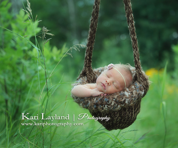 Newborn girl in sling outdoors photography