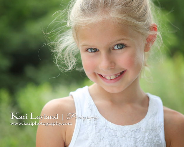 Close up photo of little girl outside using a reflector