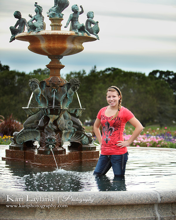 High school senior portrait of a girl standing in water fountain.  Taken in Minneapolis, MN by Kari Layland Photography.