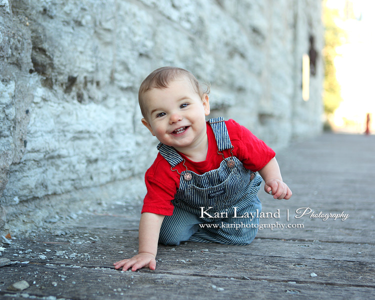 Happy baby boy picking up rocks.  Taken in Minneapolis, MN by photographer Kari Layland.