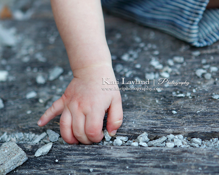 Baby hand picking up rocks.  Taken in Minneapolis, MN by photographer Kari Layland.