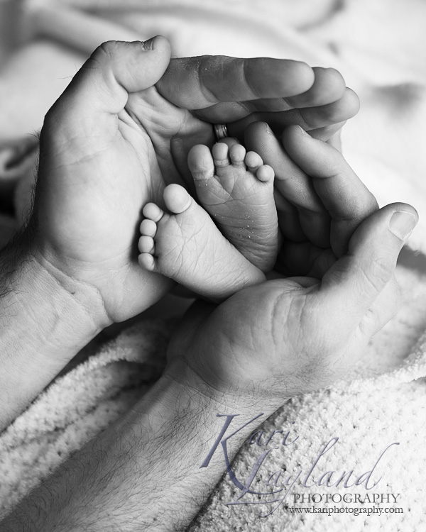 Newborn feet in daddy's hands - MN photographer Kari Layland